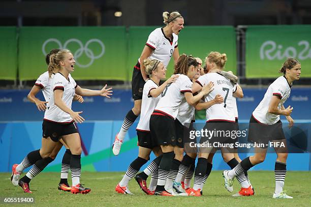 Melanie Behringer of Germany celebrates with team mates as she scores their first goal during the Women's Football Quarter Final match between China...