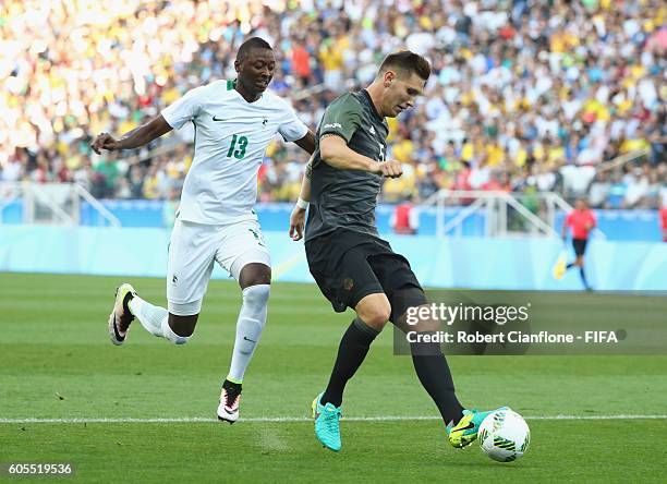 Niklas Suele of Germany is pressured by Sadiq Umar of Nigeria during the Men's Football Semi Final between Nigeria and Germany on Day 12 of the Rio...