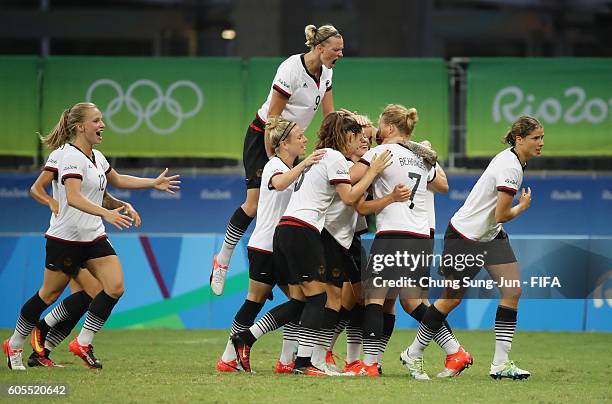 Melanie Behringer of Germany celebrates with team mates as she scores their first goal during the Women's Football Quarter Final match between China...