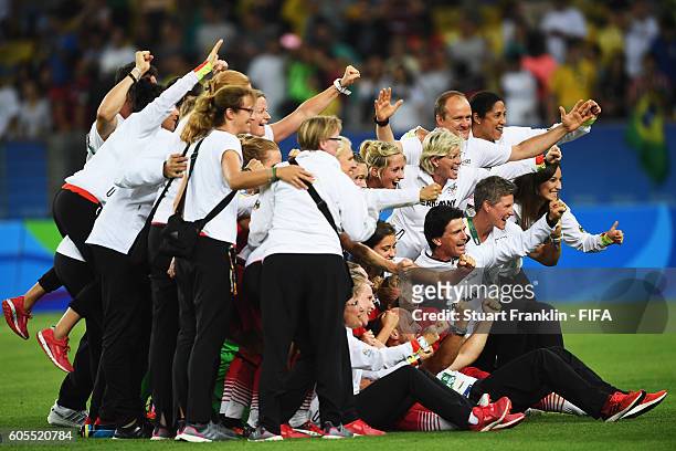 The players and officials of Geemany celebrate winning the Olympic Women's Football final between Sweden and Germany at Maracana Stadium on August...