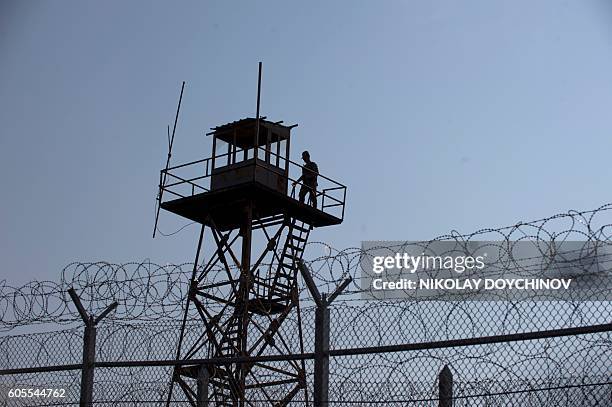 Turkey's border police personel stands on a watchtower overlooking a barbed wire wall fence erected on the Bulgaria-Turkey border near the town of...