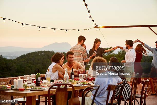 friends enjoying at patio during social gathering - leisure activity fotografías e imágenes de stock