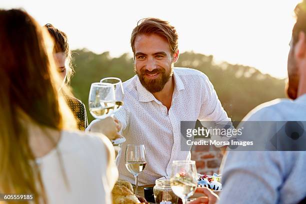 man toasting wineglass with friend - toast around the world celebration stock pictures, royalty-free photos & images