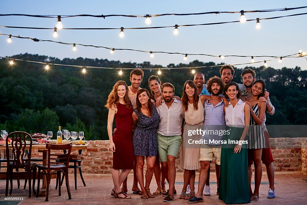 Happy friends standing at patio during gathering