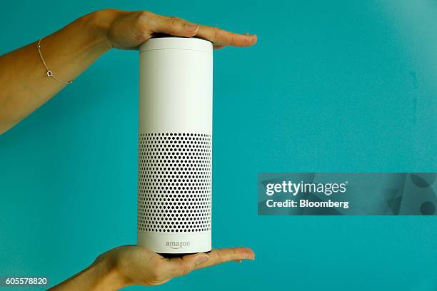 An attendee holds an "Echo" device during the U.K. Launch event for the Amazon.com Inc. Echo voice-controlled home assistant speaker in this arranged...