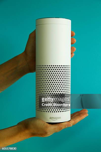 An attendee holds an "Echo" device during the U.K. Launch event for the Amazon.com Inc. Echo voice-controlled home assistant speaker in this arranged...