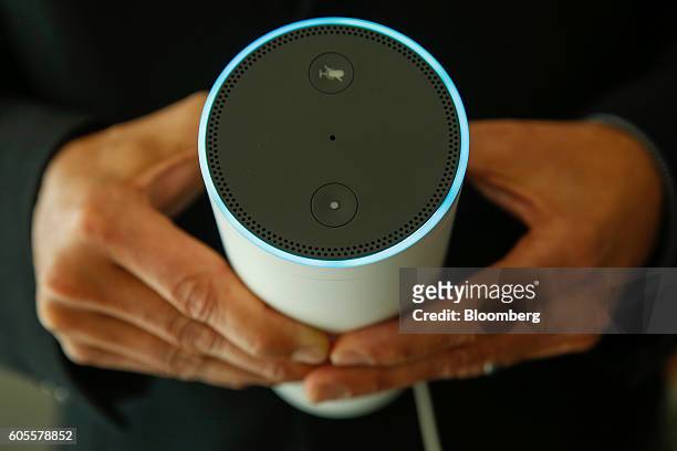 An attendee holds an "Echo" device during the U.K. Launch event for the Amazon.com Inc. Echo voice-controlled home assistant speaker in this arranged...