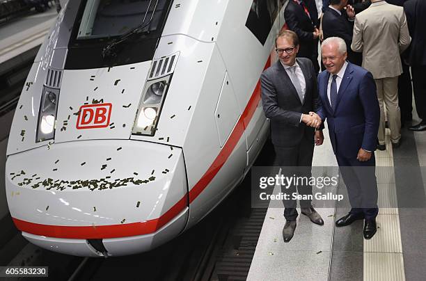 German Transport and Digital Technologies Minister Alexander Dobrindt and Deutsche Bahn head Ruediger Grube pose for the media in front of the new...