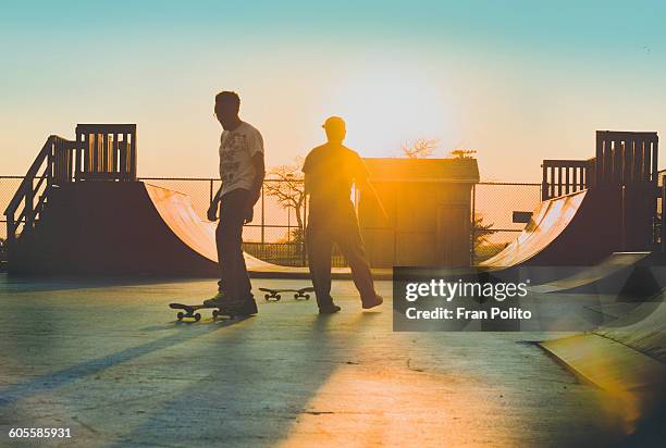 two skateboarders at the skatepark - half pipe 個照片及圖片檔