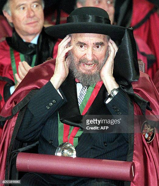 Cuban President Fidel Castro adjusts his hat after being admitted to the Brotherhood of the Porto Wine Makers at Bolsa Palace in Porto 17 October....