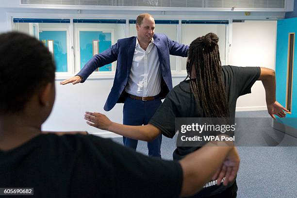 Prince William, Duke of Cambridge learns a dance move with Scariofunk Dance Collective during a visit to Caius House Youth Centre on September 14,...