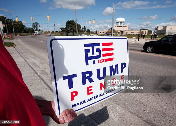 Pro-Trump supporter holds a sign while waiting for Republican presidential nominee Donald Trump to arrive for a visit to the Flint Water Treatment...