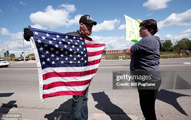 Pro-Trump supporter and an anti-Trump protestor have a discussion while waiting for Republican presidential nominee Donald Trump to arrive for a tour...