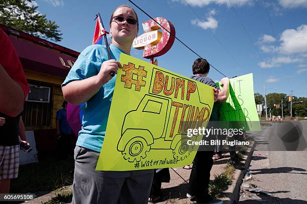 An anti-Trump protestor waits for Republican presidential nominee Donald Trump to arrive for a visit to the Flint Water Treatment Plant September 14,...