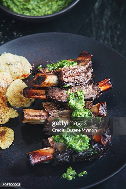 grilled beef ribs with potato chips and parsley sauce - beef ribs foto e immagini stock