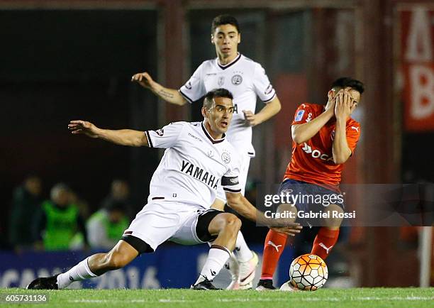 Ezequiel Barco of Independiente is fouled by Maximiliano Velazquez of Lanus during a match between Independiente and Lanus as part of Copa...