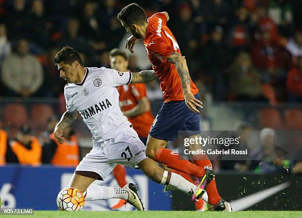 Roman Martinez of Lanus fights for the ball with Jorge Ortiz of Independiente during a match between Independiente and Lanus as part of Copa...