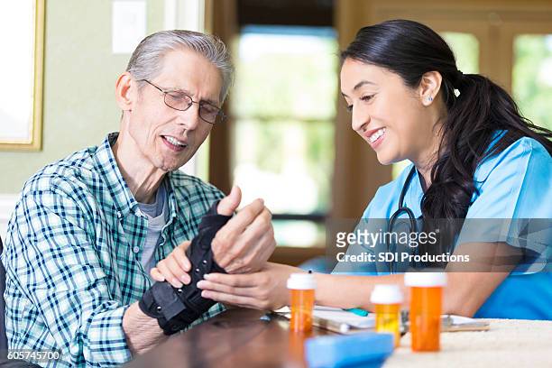 une infirmière en soins de santé à domicile examine le poignet du patient - human arm photos et images de collection