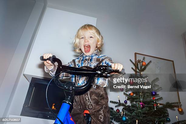 boy happy about his christmas present - trees low view stock-fotos und bilder