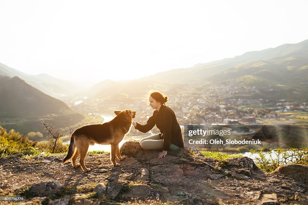 町の背景に犬と若い女の子