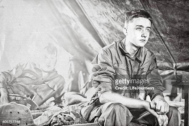 jeune fantassin de la seconde guerre mondiale assis sur un lit dans sa tente - seconde guerre mondiale photos et images de collection