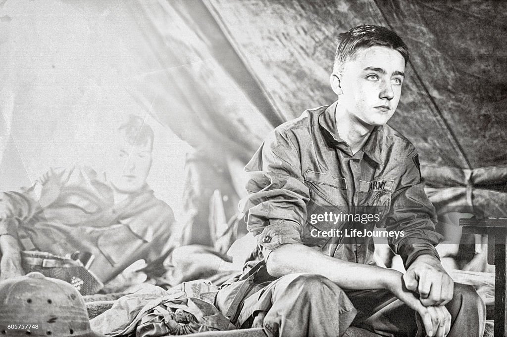 Young WWII Infantryman Sitting On A Cot In His Tent