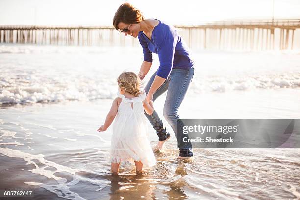 caucasian mother and daughter walking on beach - nipomo imagens e fotografias de stock