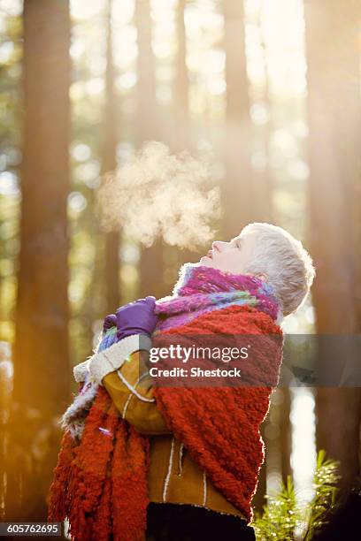 older caucasian woman breathing steam outdoors - zichtbare adem stockfoto's en -beelden