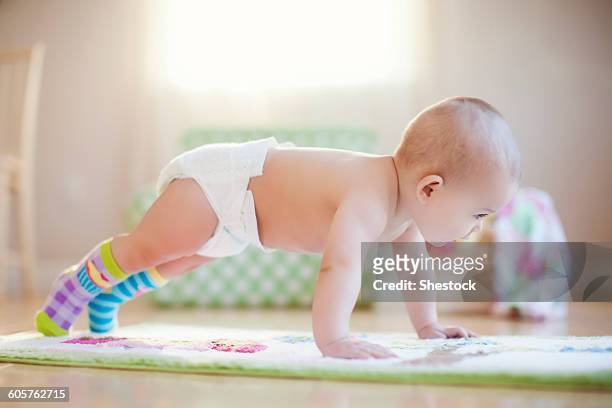 mixed race baby girl playing on floor - 這う ストックフォトと画像