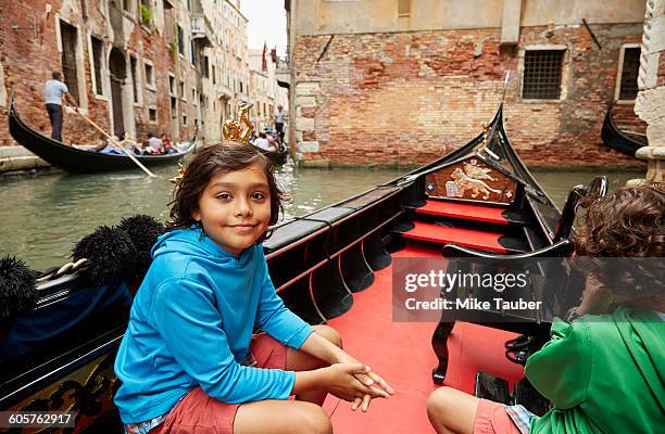 boy sitting in gondola on venice canal, veneto, italy - italy city break stock pictures, royalty-free photos & images