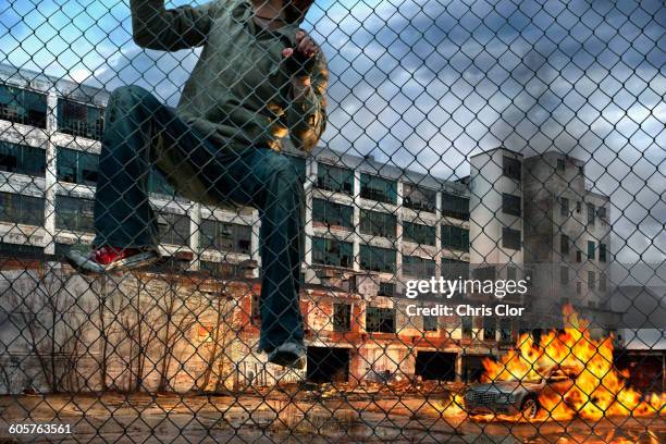 man scaling wall in gritty urban neighborhood - vandalism 個照片及圖片檔