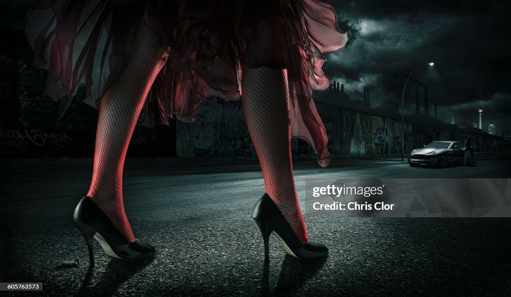 Woman wearing high heels on street at night