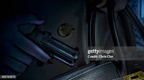 woman placing gun in purse - berlin nacht stock-grafiken, -clipart, -cartoons und -symbole