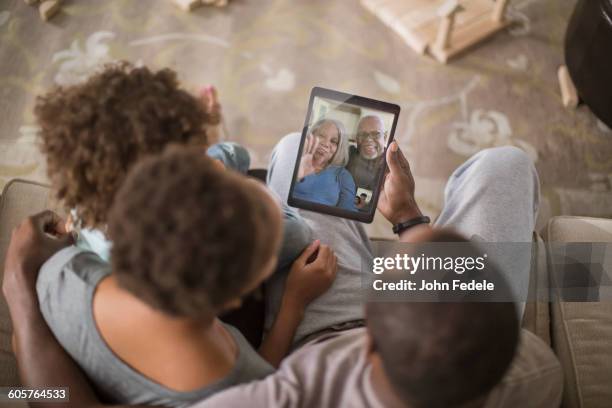 family video chatting with digital tablet - rear view photos - fotografias e filmes do acervo