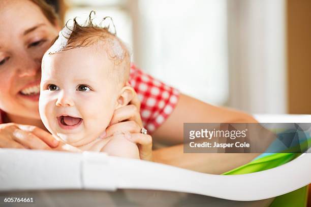 caucasian mother bathing baby daughter - woman bath tub wet hair stock pictures, royalty-free photos & images