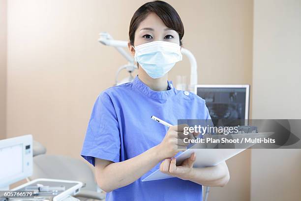 dentist wearing surgical mask and holding dental record, portrait - dental record stock pictures, royalty-free photos & images