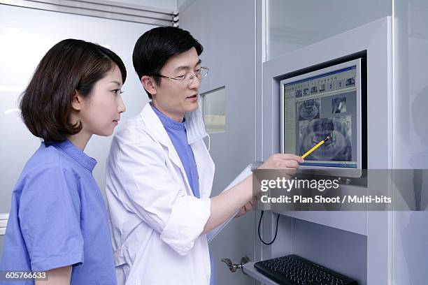 two dentist working on computer, side view - dental record stock pictures, royalty-free photos & images