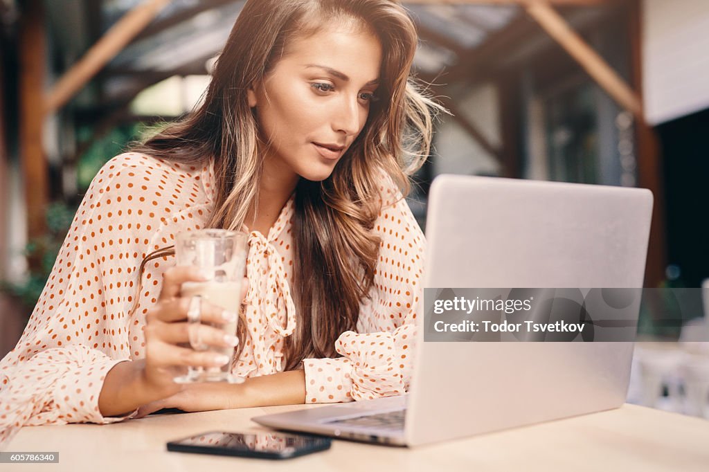 Young woman using a laptop at the cafe