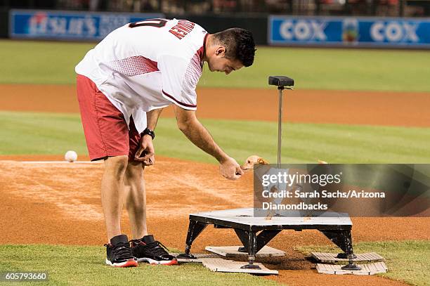 Christian Stoinev and his pet Scooby kiss a baseball for good luck prior to throwing out the first pitch at an Arizona Diamondbacks game at Chase...