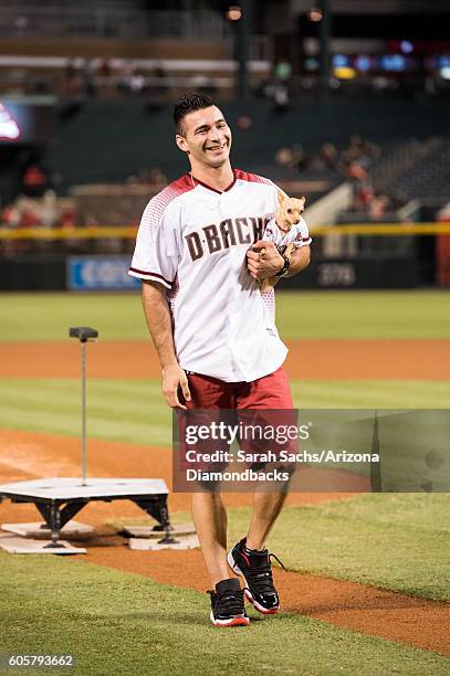 Christian Stoinev and his pet Scooby react after throwing out the ceremonial first pitch prior to the Arizona Diamondbacks game at Chase Field on...