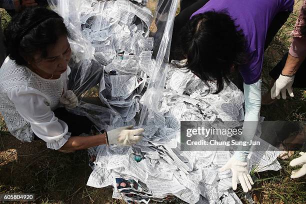 North Korean defectors, now living in South Korea, remove propaganda leaflets after their protest denouncing recent North Korea's nuclear test, near...