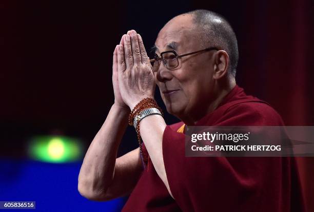 The spiritual leader of the Tibetan people the Dalai Lama gestures as he arrives for a meeting with young people on September 15, 2016 in Strasbourg,...