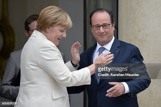 French President Francois Hollande speaks with German Chancellor Angela Merkel as she leaves the Elysee Palace after a meeting on September 15, 2016...