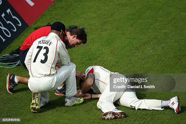 Lancashire Alviro Petersen attends to Kyle Jarvis after both collided during day four of the Specsavers County Championship Division One match...