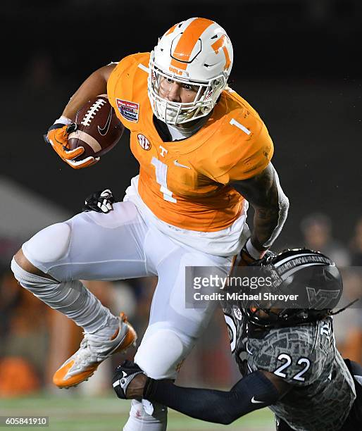 Running back Jalen Hurd of the Tennessee Volunteers is hit by rover Terrell Edmunds of the Virginia Tech Hokies in the first half at Bristol Motor...