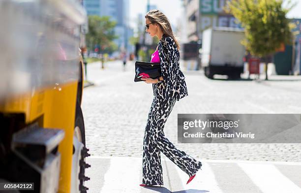 German Fashion Blogger and Model Alexandra Lapp wearing a Tom Ford suit with animal print, Jadicted pink top, Prada clutch, Dior sunglasses and...