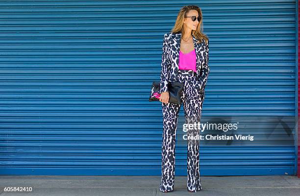 German Fashion Blogger and Model Alexandra Lapp wearing a Tom Ford suit with animal print, Jadicted pink top, Prada clutch, Dior sunglasses and...