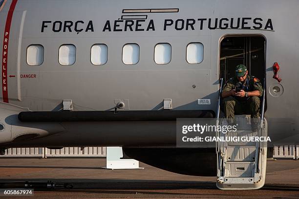 Member of the Portuguese Air Force sits on the steps of a military plane during the Africa Aerospace and Defence 2016 fair at the South African air...