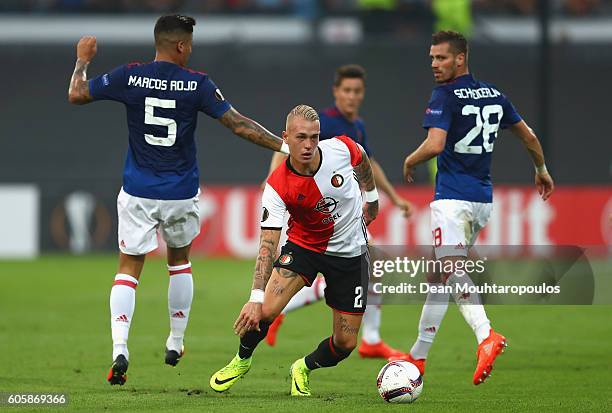 Rick Karsdorp of Feyenoord takes the ball past Marcos Rojo and Morgan Schneiderlin of Manchester United during the UEFA Europa League Group A match...