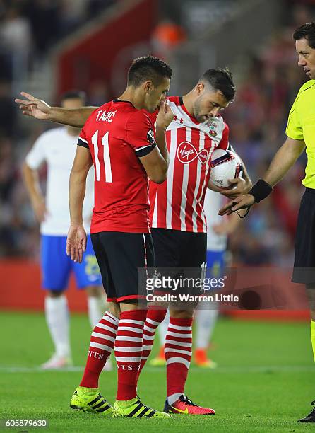 Charlie Austin of Southampton argues with teammate Dusan Tadic over who takes the penalty during the UEFA Europa League Group K match between...